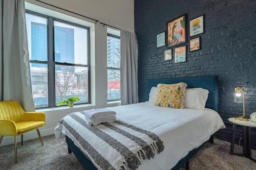 a bedroom with a bed and a chair and windows at McCormick Place 420 friendly 2br/2ba with optional parking for up to 6 guests in Chicago