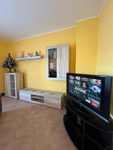 a living room with a flat screen tv and yellow walls at Cà Savoia in Bologna