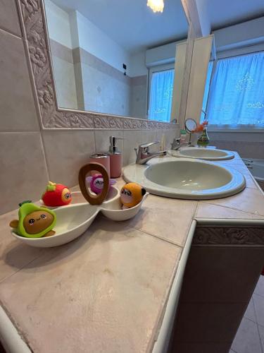 a bathroom counter with two sinks and two bowls of fruit at Cà Savoia in Bologna