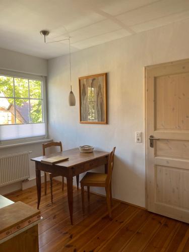 a dining room with a wooden table and a window at Ferienwohnung im Dreiseitenhof in Großräschen