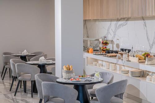 ein Restaurant mit Tischen und Stühlen, auf denen Essen steht in der Unterkunft Filia Luxury Suites in Stalida