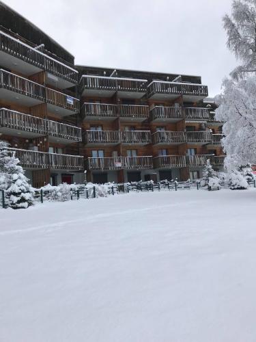 a large building with snow in front of it at LA Source Blanche in Saint-Jean Montclar