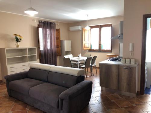 a living room with a couch and a kitchen and a table at Casa vacanze Mongibello in Milo