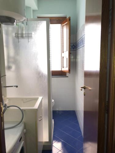 ein Bad mit einem Waschbecken, einem WC und einem Fenster in der Unterkunft Casa vacanze Mongibello in Milo