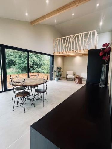 une cuisine et une salle à manger avec une table et des chaises dans l'établissement Maison de charme pleine nature pour couple, à Liessies
