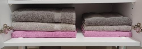 two towels are stacked on a shelf in a closet at Luminary Night Suite in Montévrain