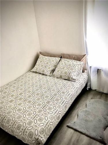- une petite chambre avec un lit doté d'une couette et d'oreillers dans l'établissement Très joli appartement à Puteaux centre ville, à Puteaux