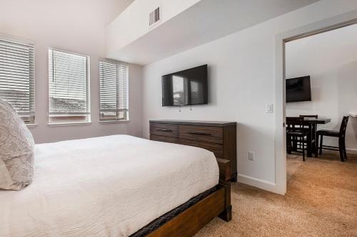 a white bedroom with a bed and a dining room at Crestview Condominiums by All Seasons Resort Lodging in Park City