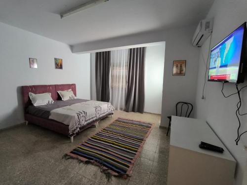 1 dormitorio con 1 cama y TV de pantalla plana en Spacious 3 room apartment Prime Location on 2nd Floor with proximity to all amenities en Sfax