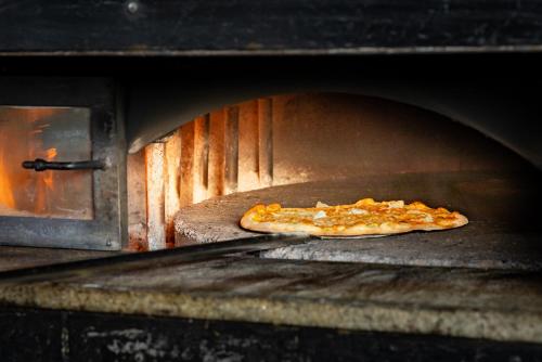 a pizza is coming out of an oven at Hotel Sonne St. Moritz 3* Superior in St. Moritz