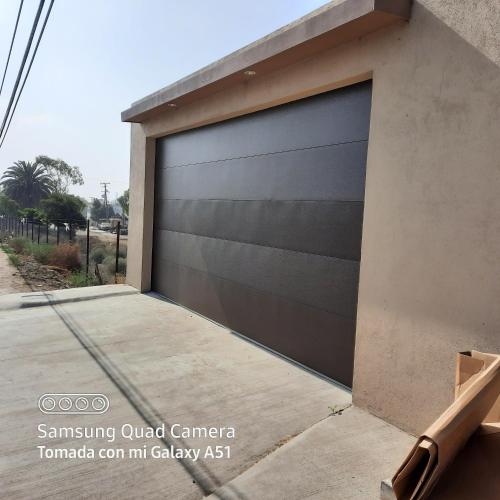 uma porta de garagem ao lado de uma casa em Casa en renta Rosarito em Santa Mónica Sur