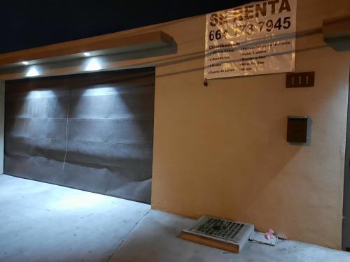 uma porta de garagem com um sinal na parede em Casa en renta Rosarito em Santa Mónica Sur