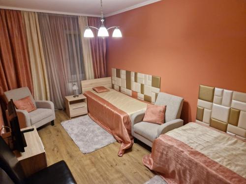 セクサールドにあるCentrum Business Apartman Szekszárdのベッドルーム1室(ベッド1台、ソファ、椅子付)