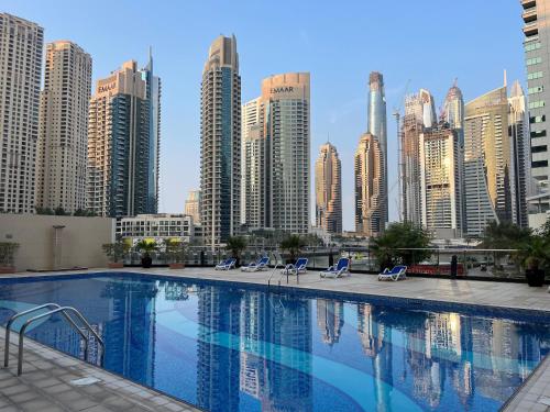 a large swimming pool in a city with tall buildings at Amazing 1 bedroom apt in Marina in Dubai