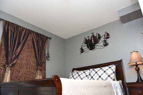 a bedroom with a bed and a lamp and curtains at Sam & Comfort Home in St. John's