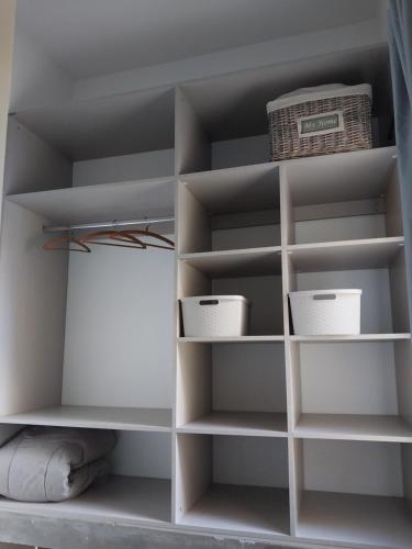 un armario con estanterías blancas y una cesta en La Casa de Bimba en Gualeguaychú