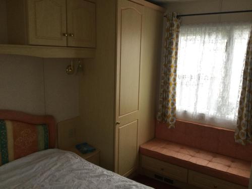 H2 في آبريستويث: غرفة نوم صغيرة بها سرير ونافذة