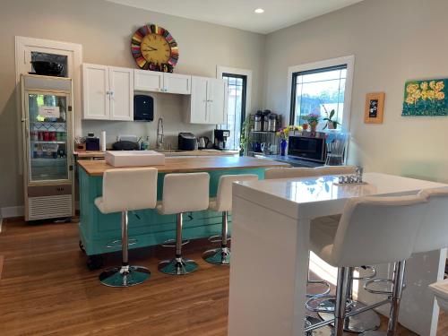 a kitchen with white cabinets and a counter with bar stools at VIP Suites for Business Women, Nurses, College Moms Traveling to Indianapolis in Indianapolis