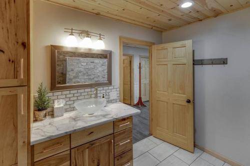 a bathroom with a sink and a mirror at Cozy Home, Hot Tub, Dock, Kayaks, Swimming & More! in Woodrow