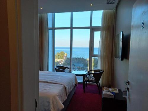 um quarto de hotel com uma cama e uma grande janela em Blue Waves Abu Halifa أمواج الخليج الزرقاء em Kuwait
