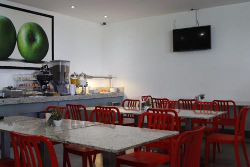 une salle à manger avec des tables et des chaises rouges dans l'établissement Hotel México Plaza Silao Aeropuerto, à Silao