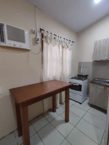 a kitchen with a wooden table and a microwave at Apart da Cachoeira in Florianópolis