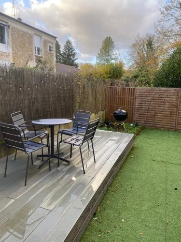a patio with chairs and a table and a grill at Appartement avec jardin privé à 10 min de Disneyland, idéal familles in Couilly-Pont-aux-Dames