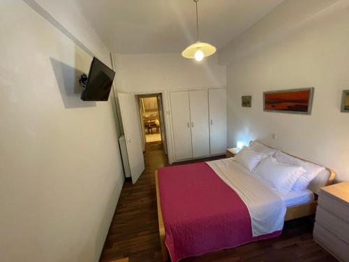 - une petite chambre avec un lit et une télévision dans l'établissement Διαμερίσμα με 1 κρεβατοκάμαρα και ένα σαλόνι, à Athènes