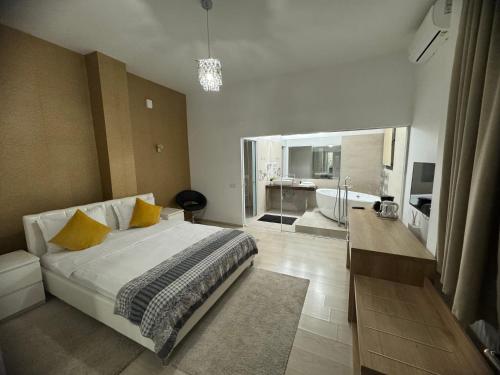 a bedroom with a bed and a bathroom with a tub at Premium Residence in Braşov