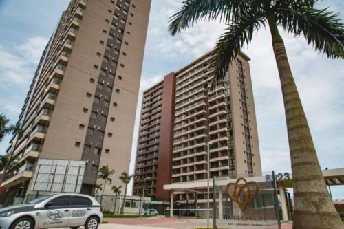 dos edificios altos con un coche aparcado en un estacionamiento en Apartamento Rio de Janeiro, en Río de Janeiro