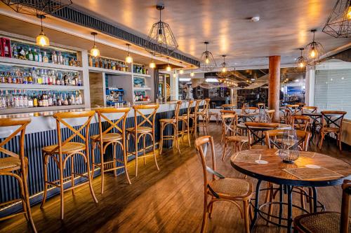 a restaurant with tables and chairs and a bar at Hotel Gavina Costa Mar in Iquique