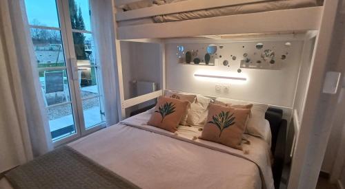 a small bedroom with a bunk bed with a window at Luminary Night Suite in Montévrain