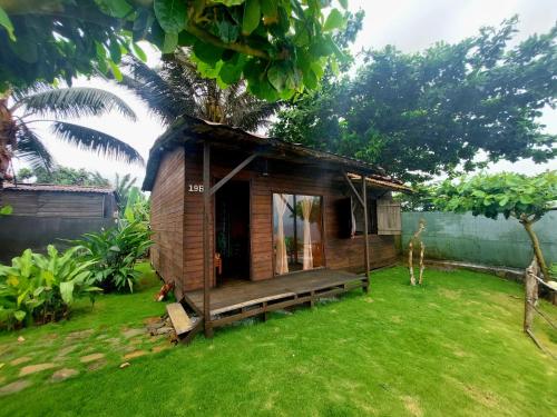 a small house with a porch and a grass yard at GENTE D'AQUI Ngê D'ai êê in São Tomé
