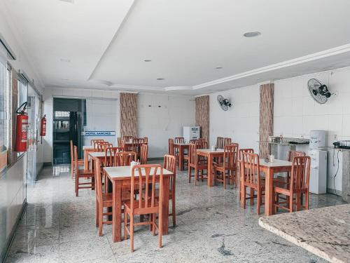 a dining room with wooden tables and chairs at Hotel Sanches in São Mateus