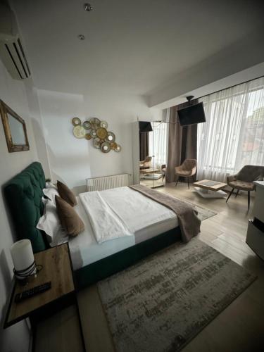 a bedroom with a large bed and a living room at Premium Residence in Braşov