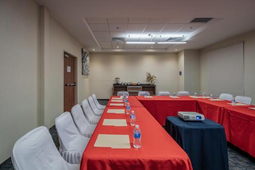 a conference room with red tables and white chairs at La Venta Inn Ciudad del Carmen in Ciudad del Carmen