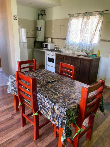 a kitchen with a table with four chairs and a kitchen with a stove at CATALINA 2 in Neuquén