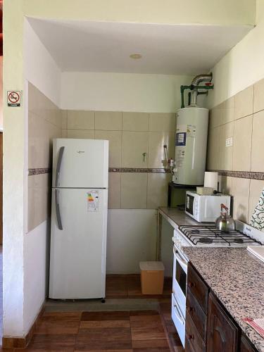een keuken met een witte koelkast en een fornuis bij CATALINA 2 in Neuquén