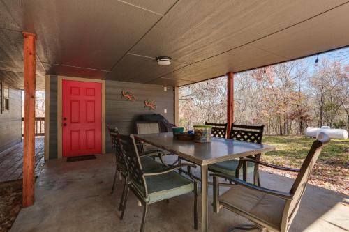 a dining room with a table and chairs and a red door at about 3 Mi to Lake Texoma Kingston Family Retreat in Kingston