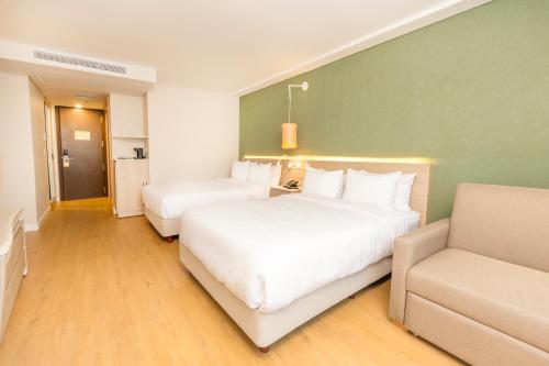 a hotel room with two beds and a couch at Grand Sirenis San Andres in San Andrés