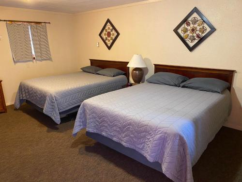 two beds in a hotel room with two bedsskirts at The Willows Motel in Wilbur