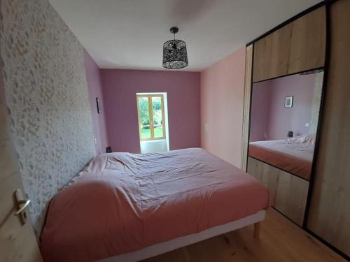 a pink bedroom with a bed and a mirror at Gite de la croix de Fénelon in Masclat
