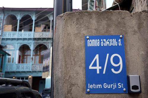 a sign on a wall in front of a building at Eva's Pavaroti in Tbilisi City