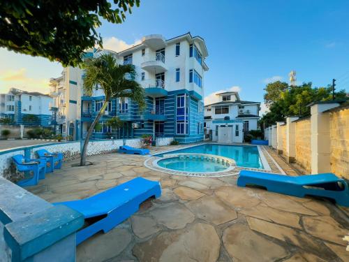 una piscina con bancos azules frente a un edificio en Majestic Homes, en Nyali