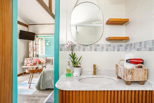 a bathroom with a sink and a mirror at Paradise Bangalô in Florianópolis