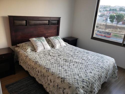 Un dormitorio con una cama grande y una ventana en Hermoso y cómodo departamento en Viña del Mar, en Viña del Mar