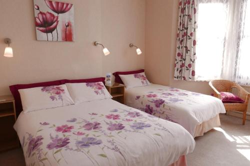 1 dormitorio con 2 camas y ventana en Abbey Guest House, en Norwich