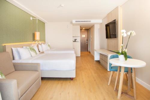 a hotel room with a large bed and a couch at Grand Sirenis San Andres in San Andrés