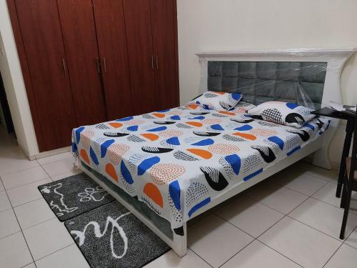 BEAUTIFUL VACATION HOME AT DUBAI BY MAUON TOURISM في دبي: سرير مع لحاف ومخدات في غرفة النوم
