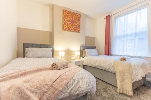 um quarto com 2 camas e uma janela em STAYZED R - Urban Oasis NG7, Walking Distance From City Centre & Lots of Amenities - Large bedrooms, Perfect for Work, Tourism, Family and Contractors - Long Stays Welcome em Nottingham